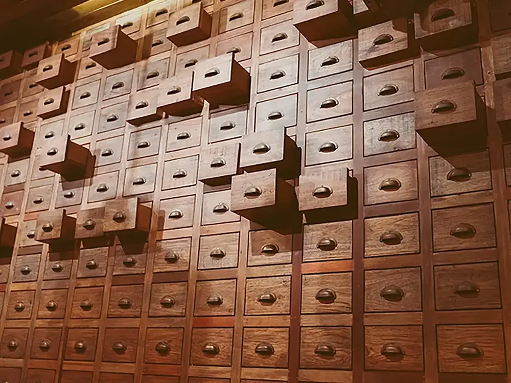 A wall of drawers with some in various stages of opening.