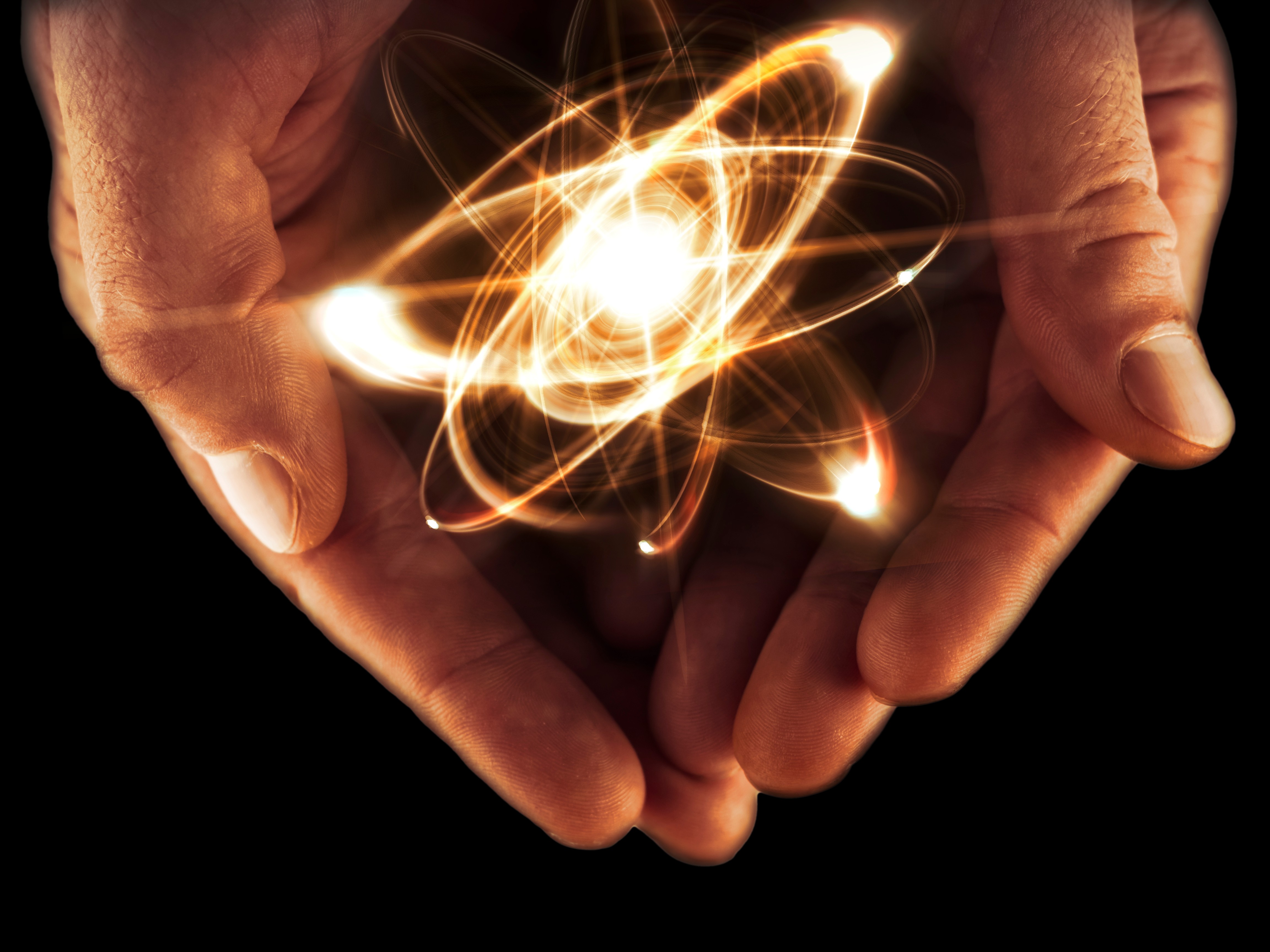 Hands holding an atom.