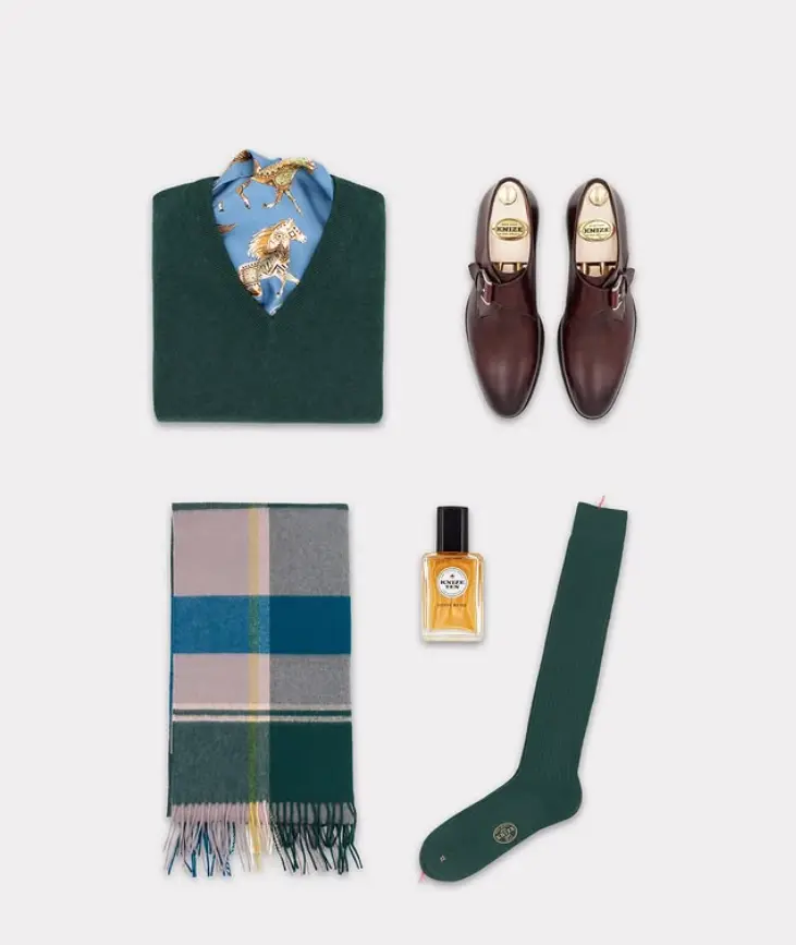 Image Credit: Knize Knize wardrobe accessories arranged with shoes, scarf, socks, and a bottle of house fragrance.