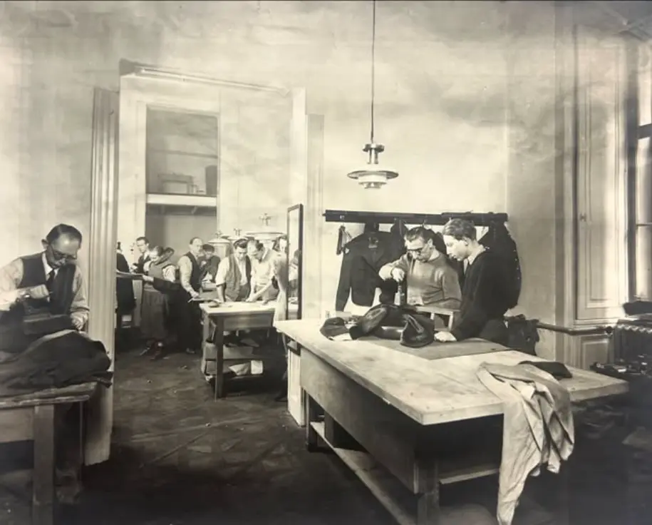 Image Credit: Knize Historic black-and-white photograph of tailors working in the Knize workshop.
