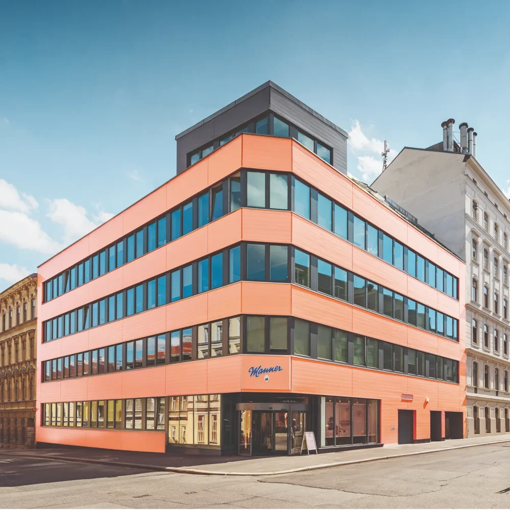 Image Credit: Manner Manner company building in Vienna with pink façade and Manner logo above the entrance.
