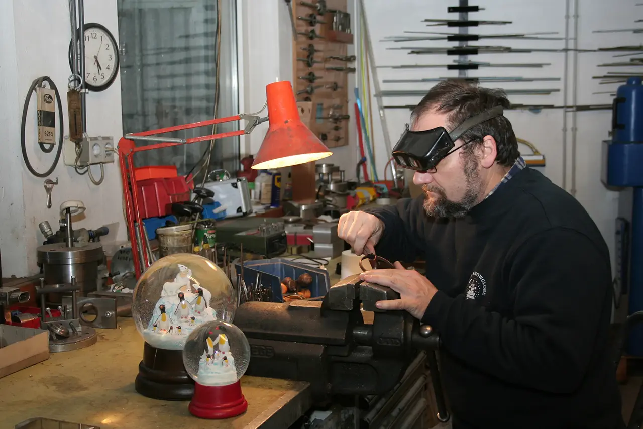 Image Credit: Image Credit: Wiener Schneekugel Manufaktur An Artisan in the Process of Manufacturing a Snowglobe