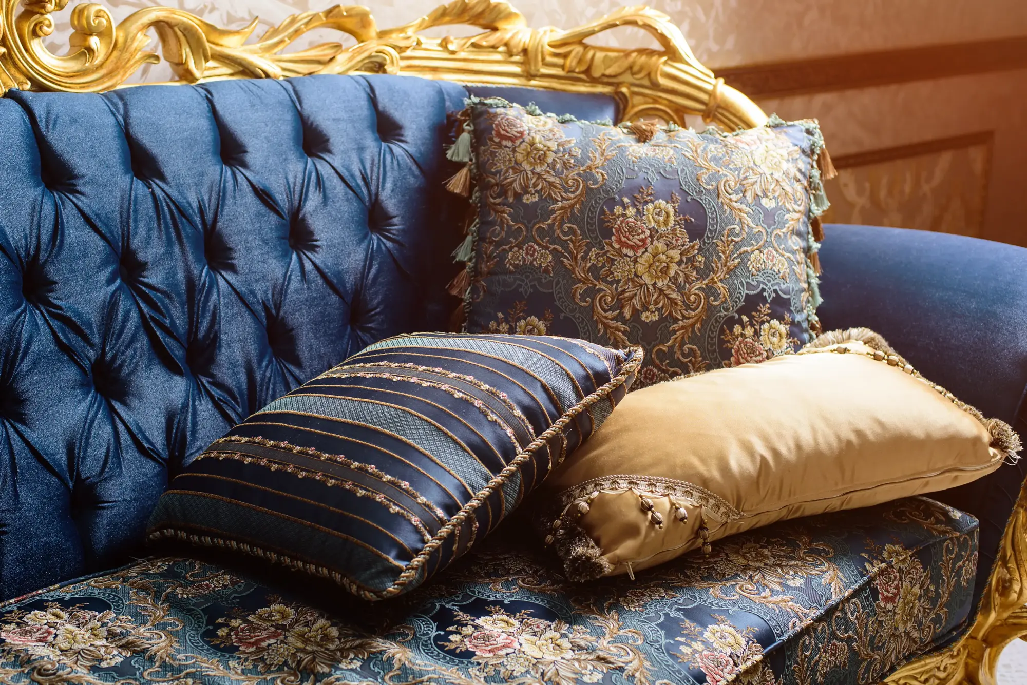 Close up of three silk cushions on 19th centruy style settee with gilt wooden frame
